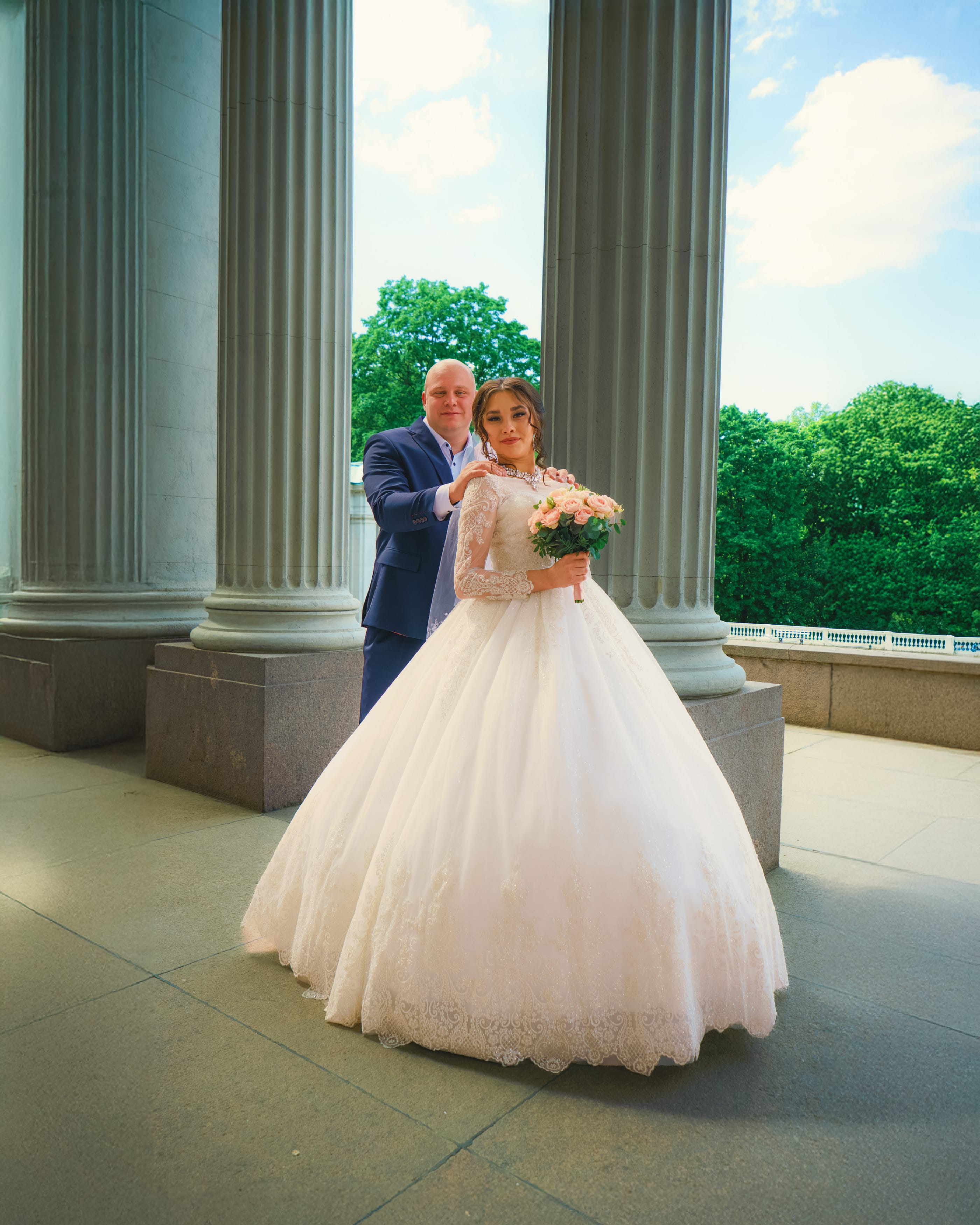 Фотография элегантной женщины в пышном платье в полумраке, с колоннами и акцентом на роскошь и таинственность.